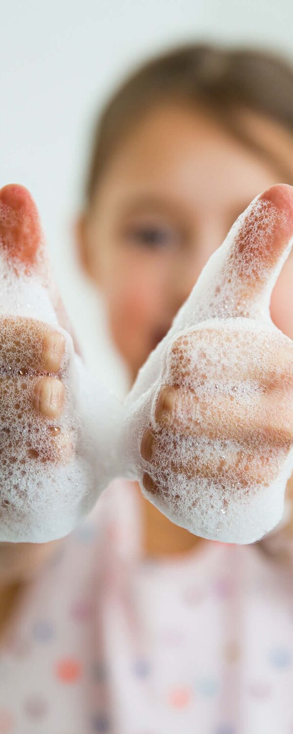 Mädchen hält ihre frisch gewaschenen Hände nach oben